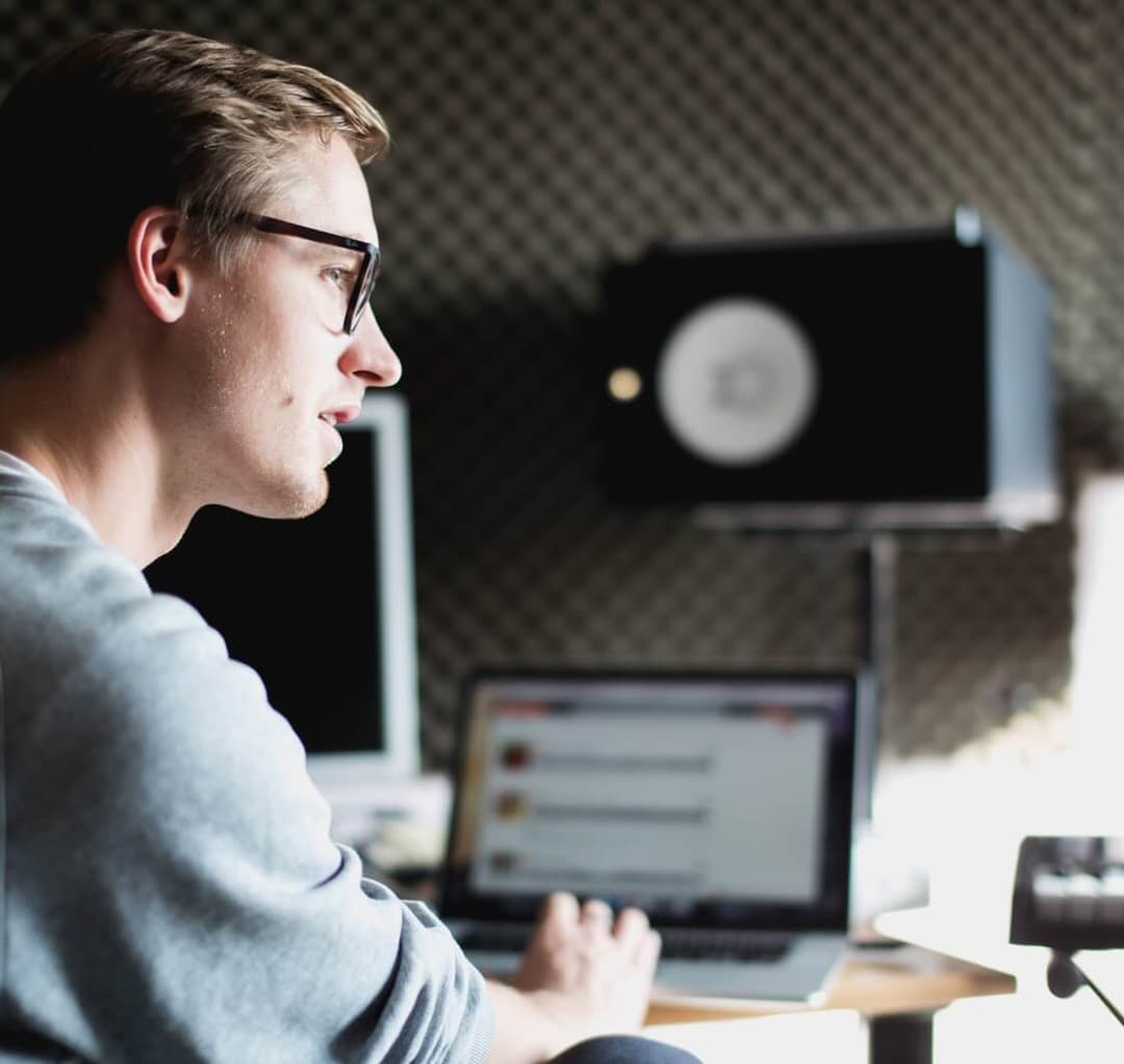 Music producing man in front of laptop amplifier in the background