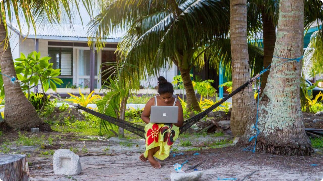 woman working remotely on a hammock with laptop