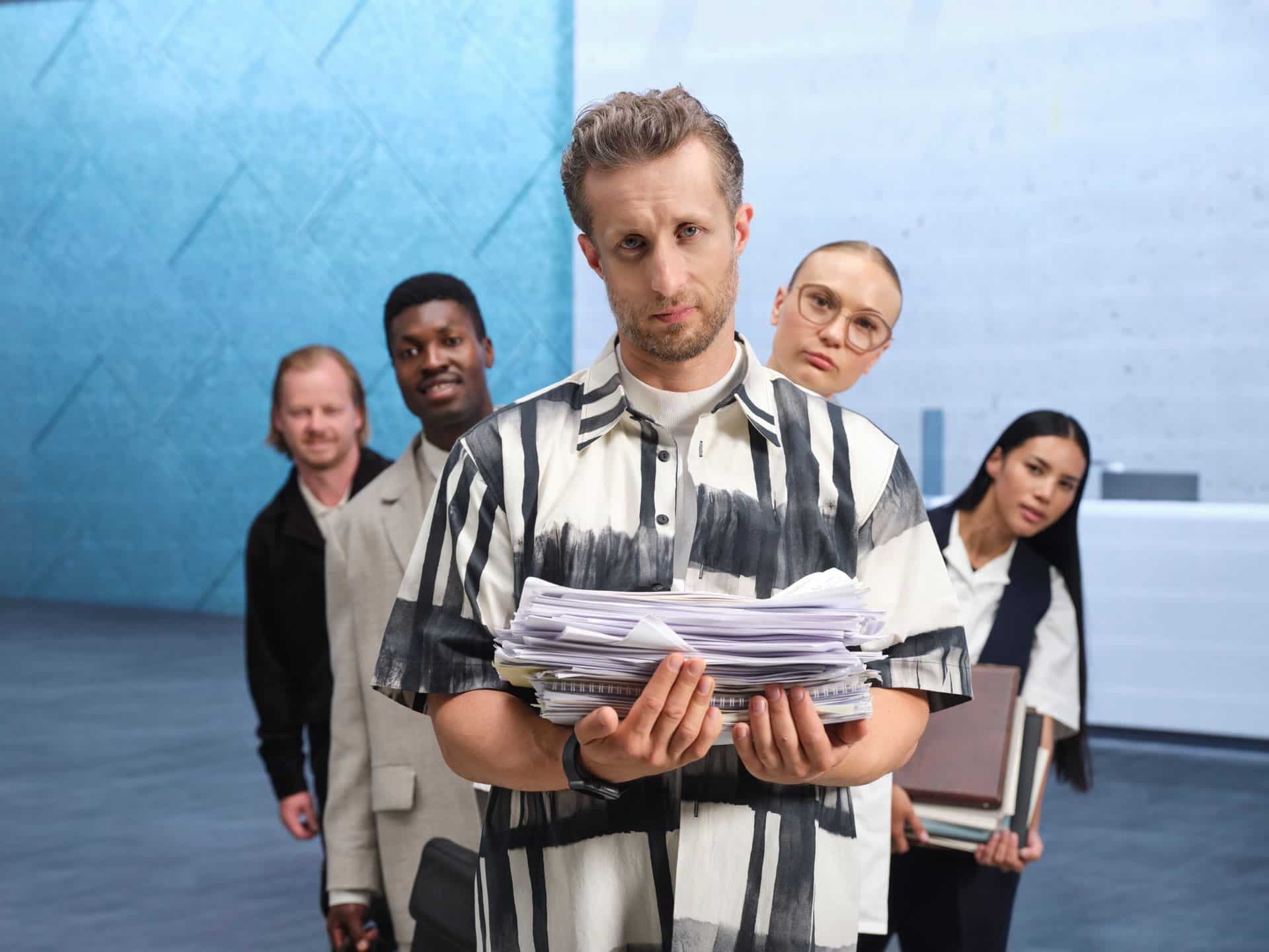 A sad man trying to expand his business holds a lot of paperwork