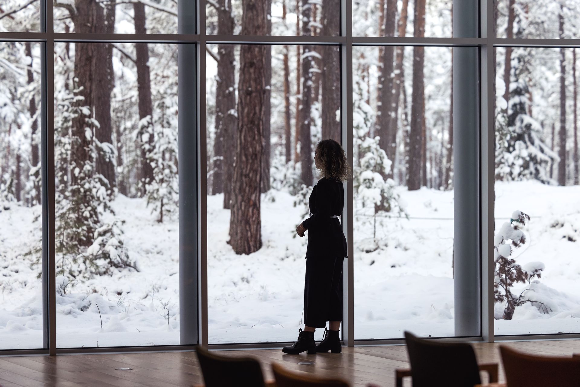 A businesswoman looking out to a snowy forest