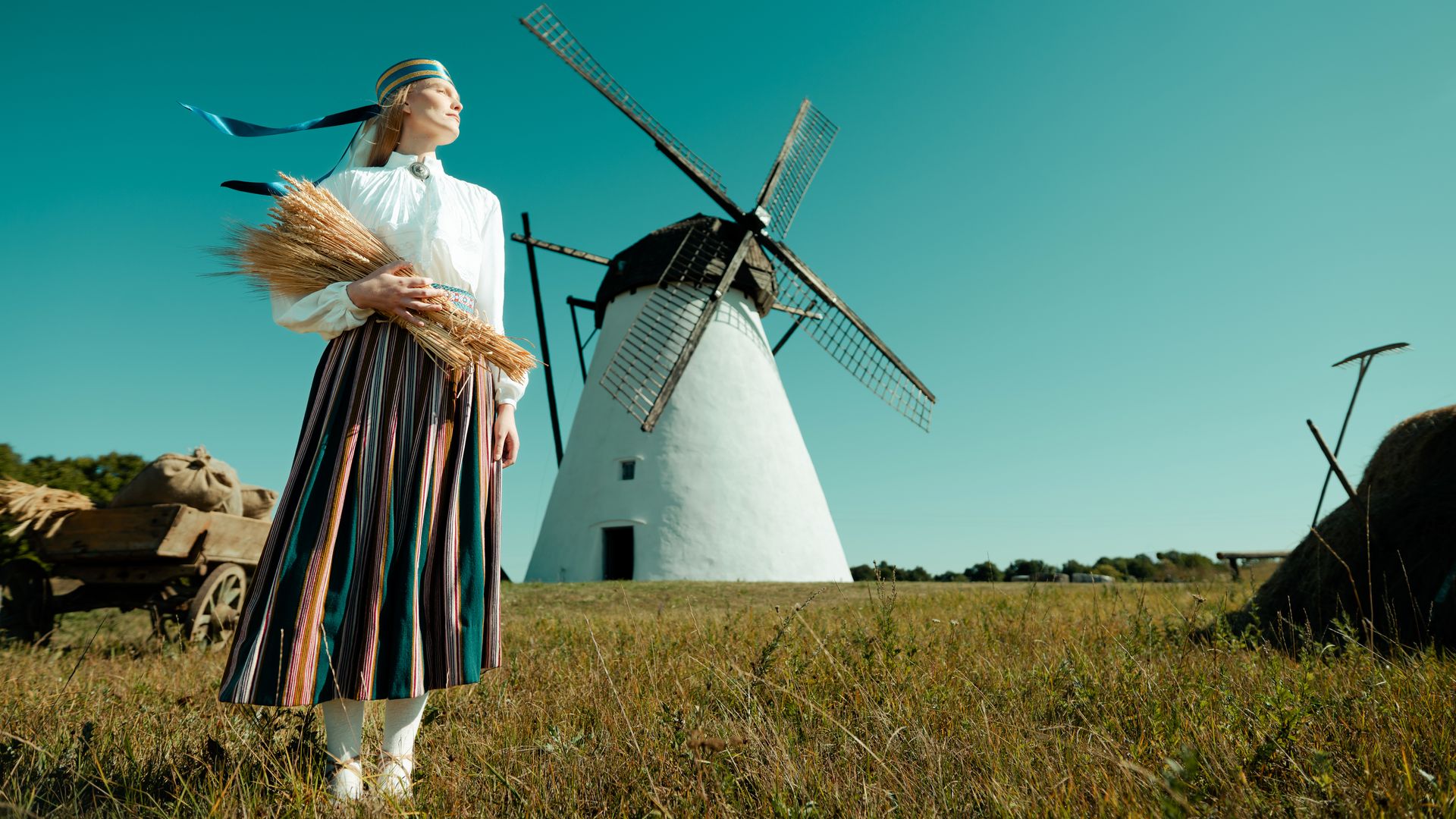 Investing in Estonia: how can e-residents do so with their companies there? A girl in traditional Estonian clothes and a windmill in the background
