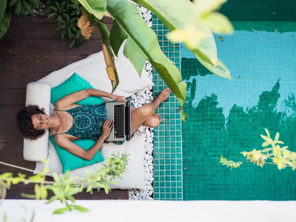 Manage a company remotely from anywhere, including by the pool as this digital nomad is doing