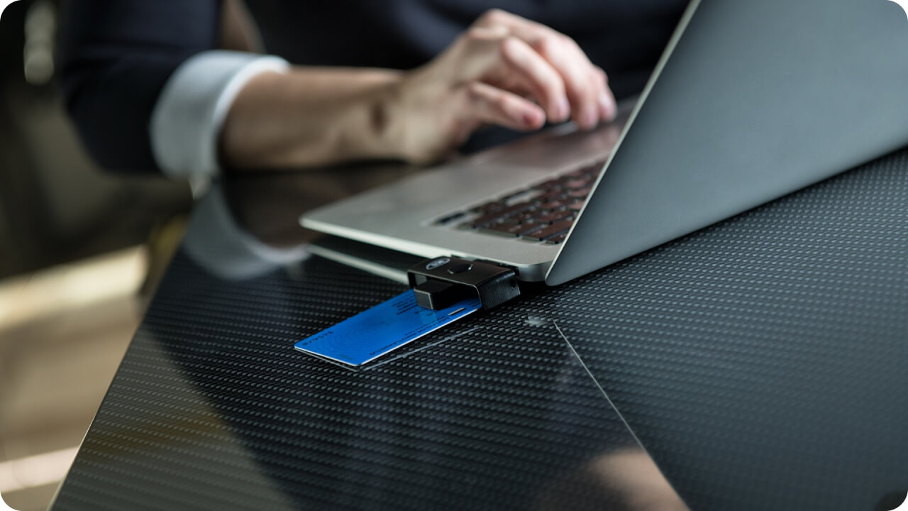 Person behind a laptop with e-Residency card connected