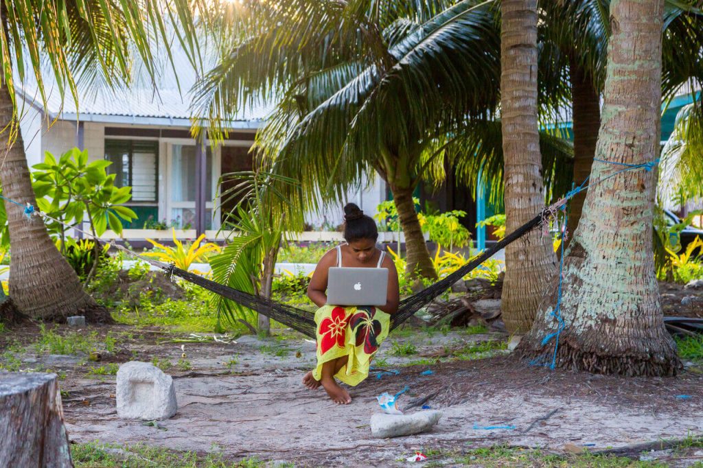 What makes a digital nation? A woman in Tuvalue on a laptop on a hammock.