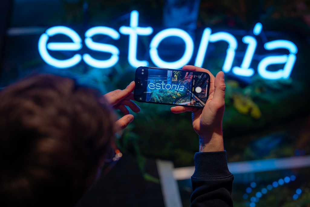 Man taking photo of Estonia sign