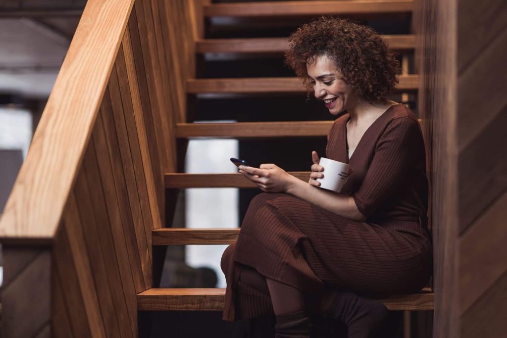 A woman using social media on her phone for personal branding