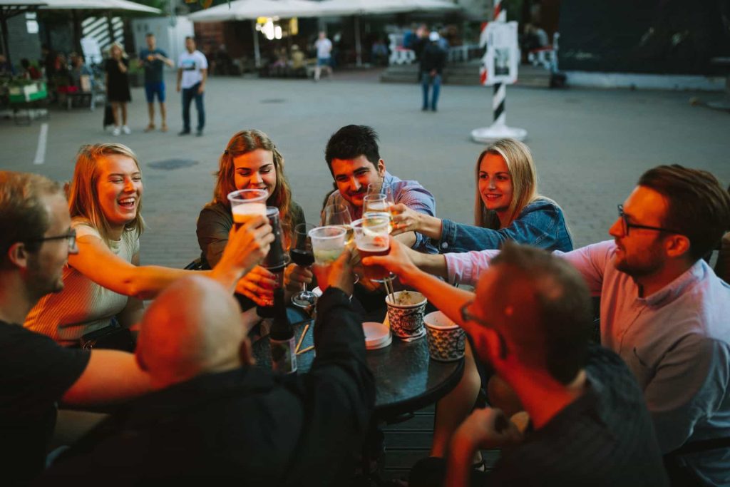 A group of friends celebrates at a bar with a toast