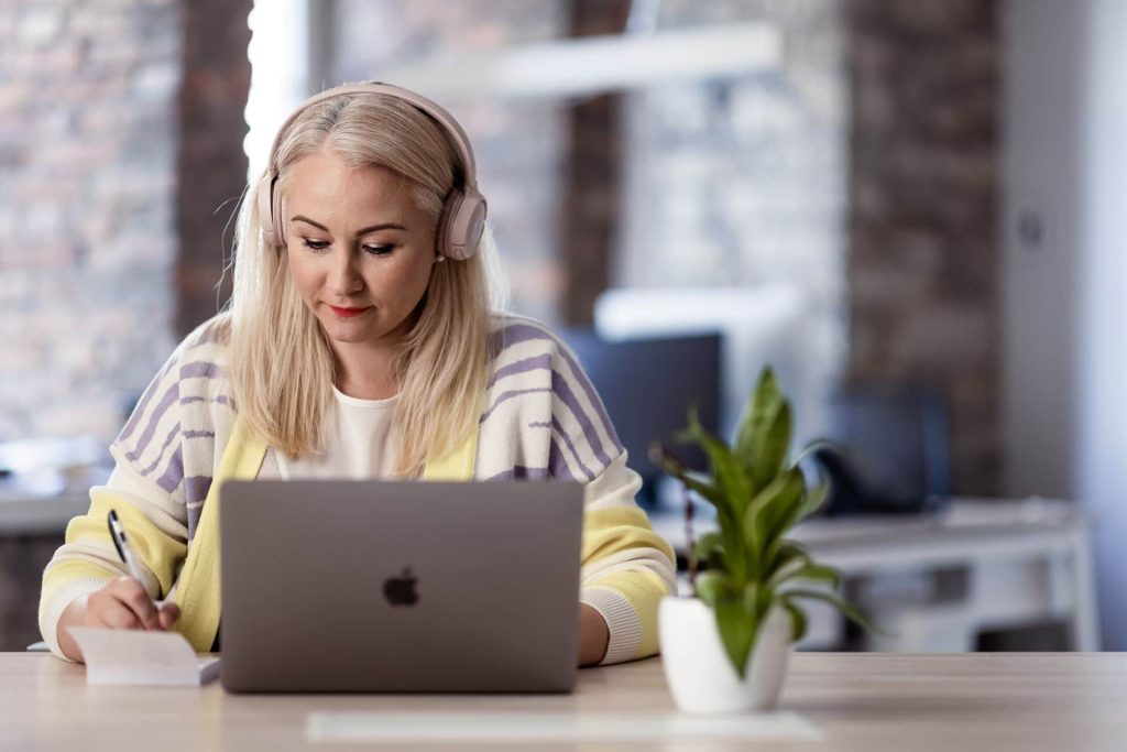 A woman remotely managing a team from her laptop