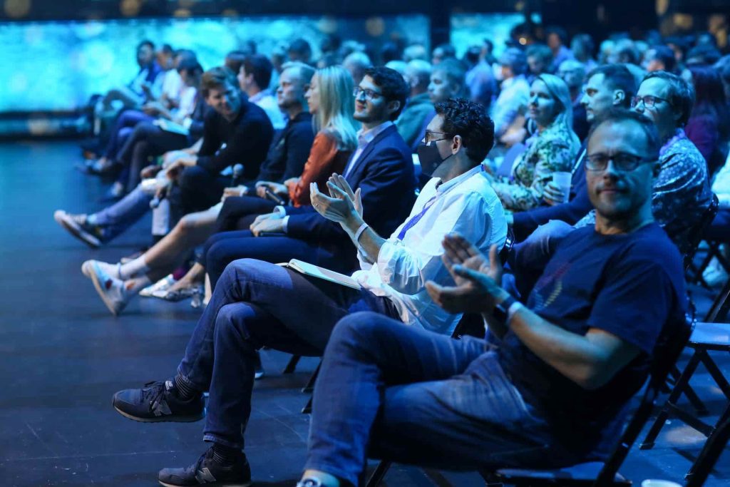An audience watches a speaker
