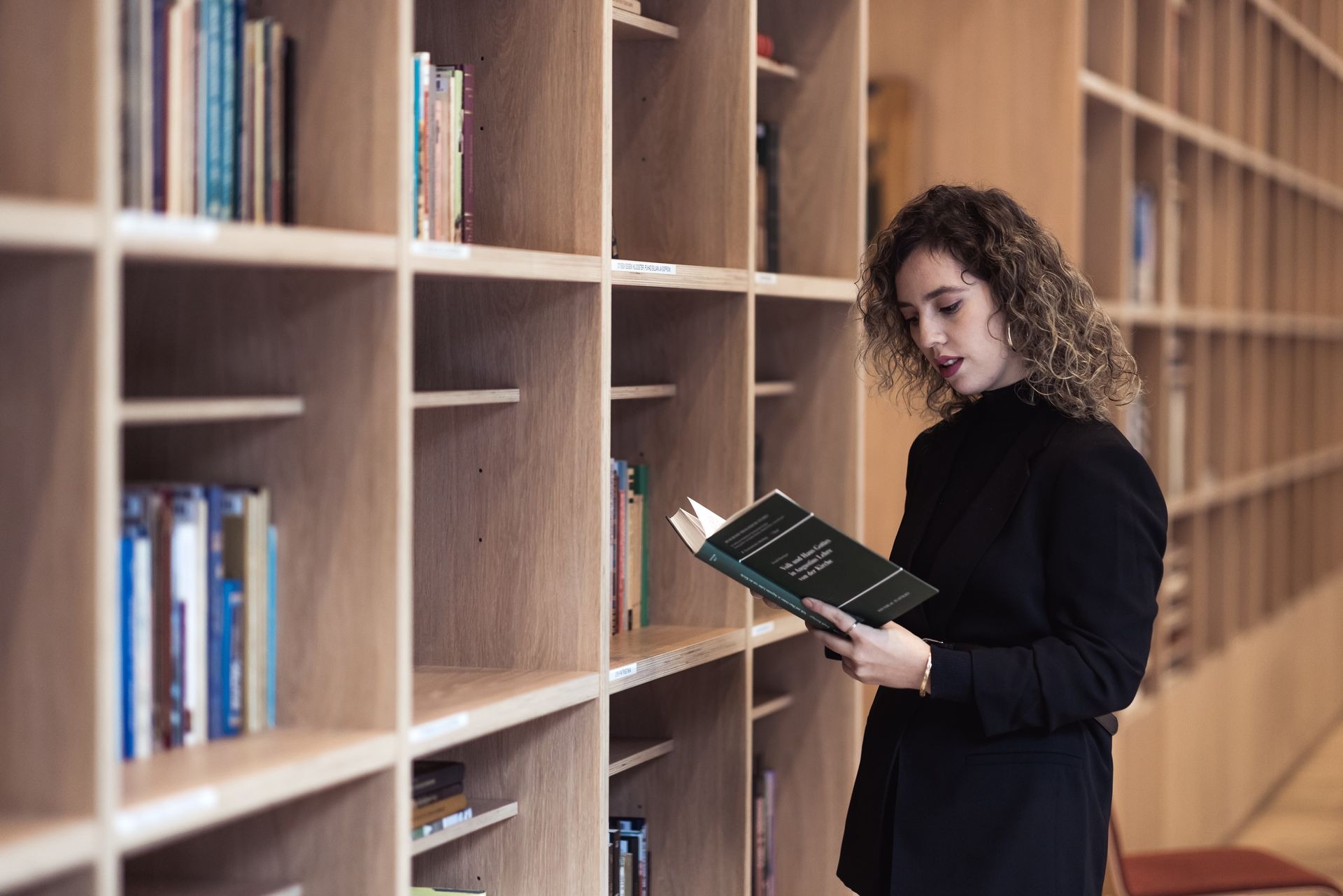 A woman reading a book in a library