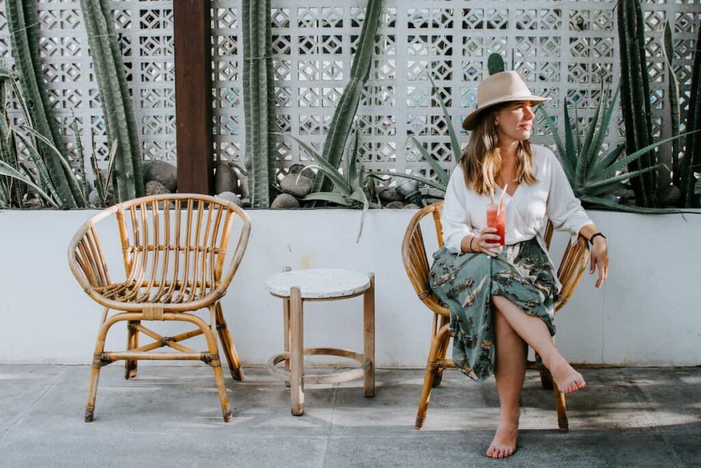 Saskia Mardi, e-resident, sitting in a chair with a tropical drink in front of cacti