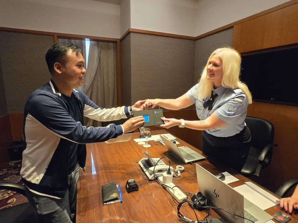 Merike Aspe-Kangro of the Estonian Police and Border Guard Board issuing an e-resident his card
